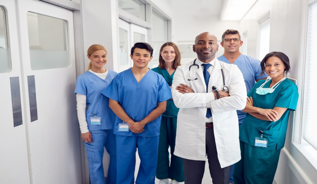 A group of doctors and nurses standing in a hospital hallway.