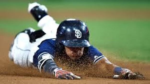 A baseball player sliding head first into a base.